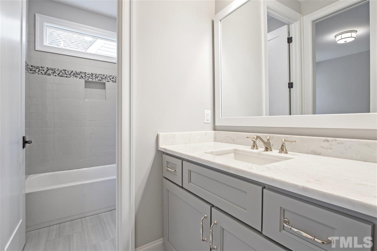 3019 Lewis Farm Road Raleigh, NC 27607 - Photo 30 of 30 a bathroom with a granite countertop sink and a mirror