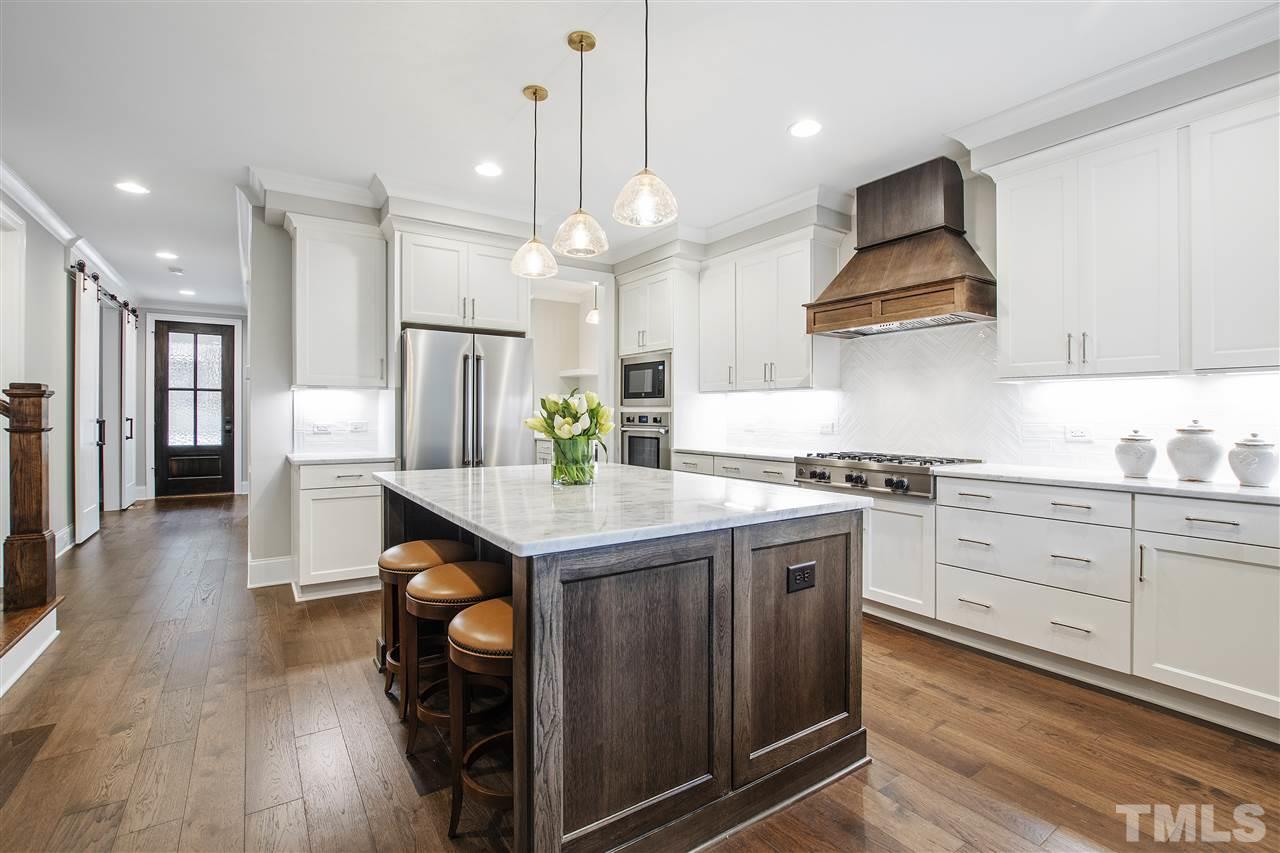 3019 Lewis Farm Road Raleigh, NC 27607 - Photo 6 of 30 a kitchen with stainless steel appliances granite countertop a sink a stove a refrigerator and island with wooden floor