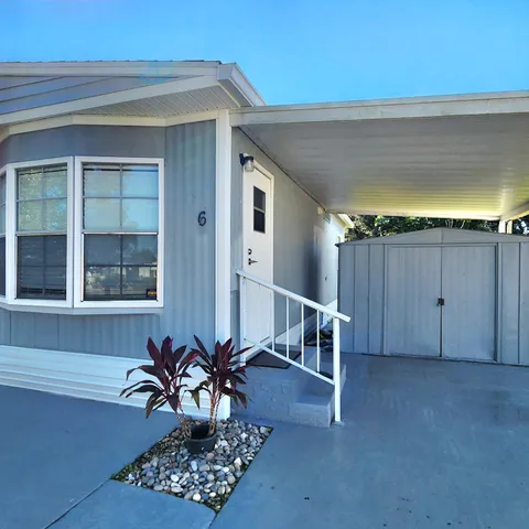 a large kitchen with kitchen island a sink dishwasher a stove a refrigerator and white cabinets with wooden floor