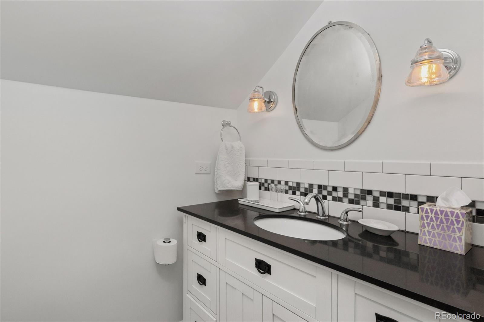2073 South Perry Park Road Sedalia, CO 80135 - Photo 19 of 40 a bathroom with a sink and a mirror