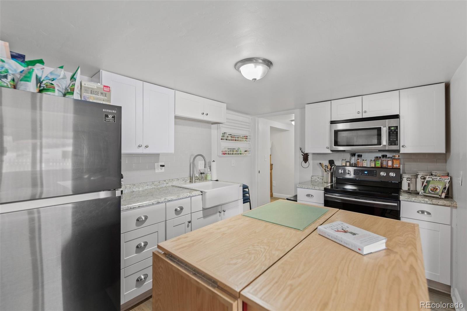 2073 South Perry Park Road Sedalia, CO 80135 - Photo 38 of 40 a kitchen with stainless steel appliances a stove refrigerator sink and microwave