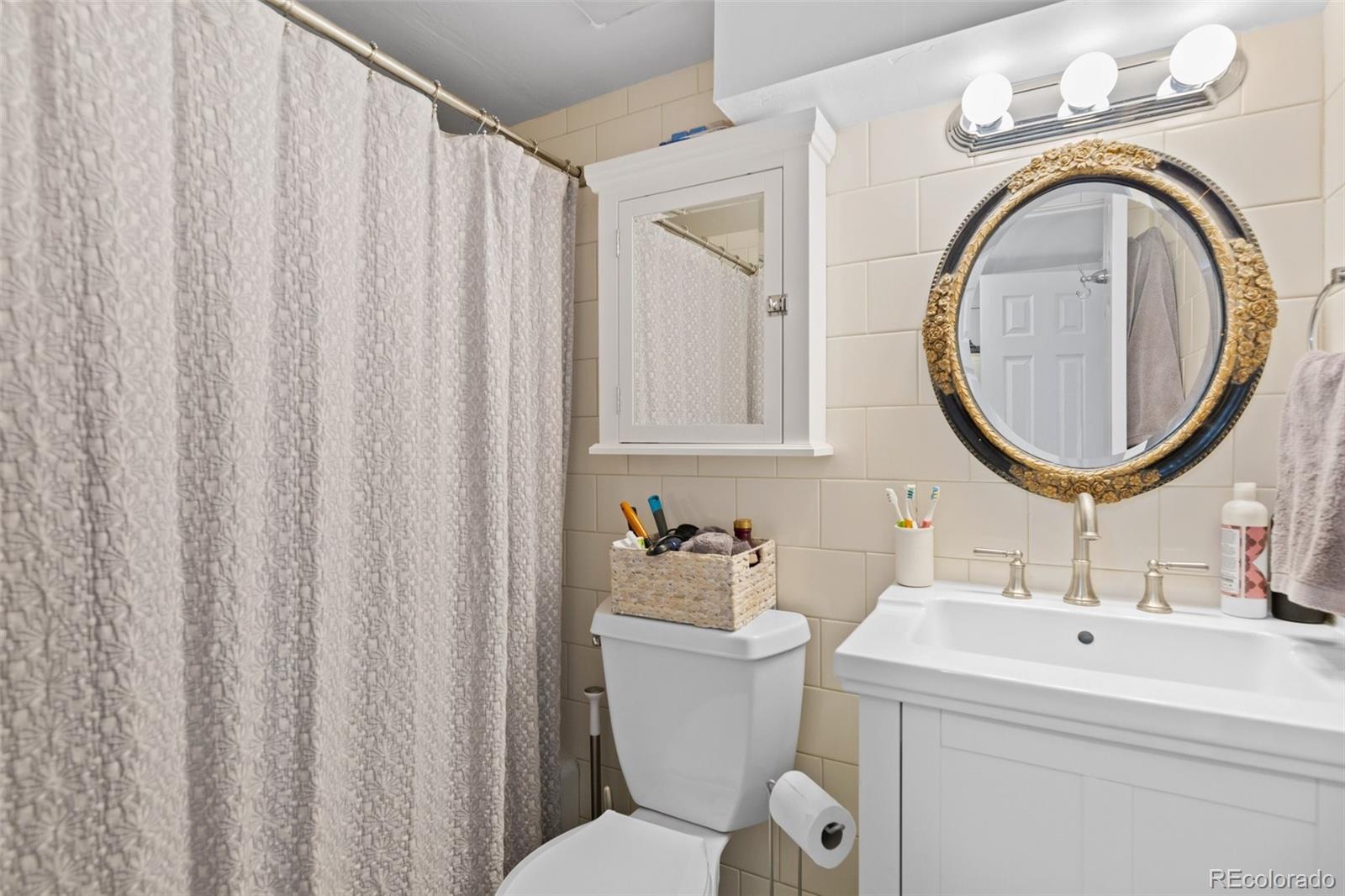 2073 South Perry Park Road Sedalia, CO 80135 - Photo 39 of 40 a bathroom with a sink a mirror a toilet and a sink