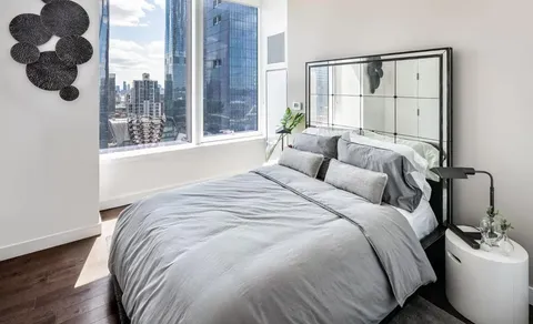 a bedroom with a bed and a large window