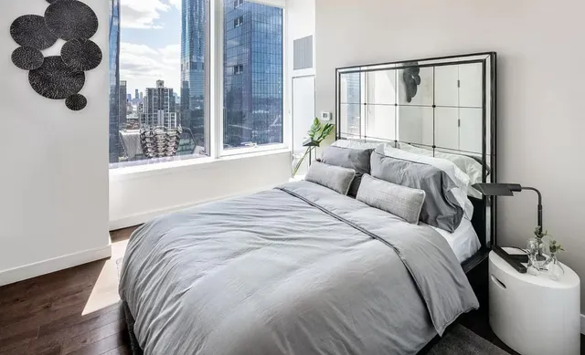 a bedroom with a bed and a large window