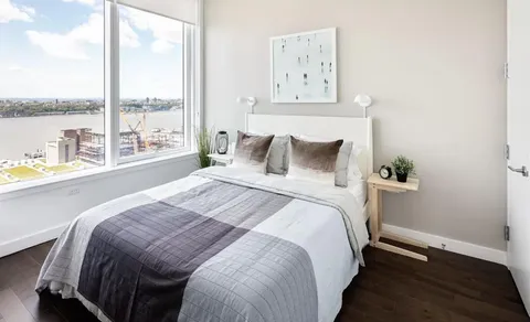 a bedroom with a bed and a large window