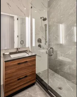 a bathroom with a granite countertop sink mirror and shower