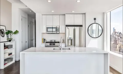 a kitchen with a refrigerator a sink and a stove top oven