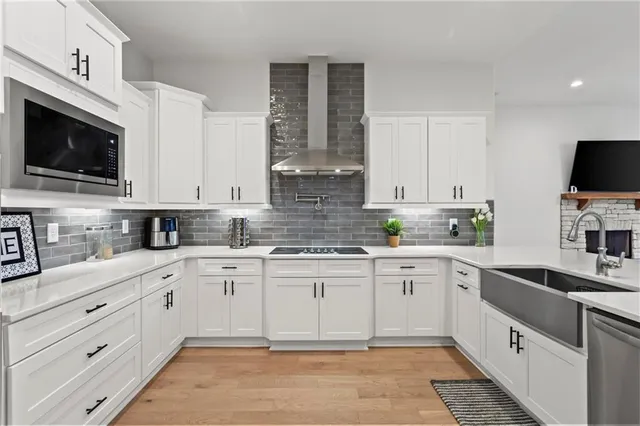 a kitchen with cabinets stainless steel appliances and a sink