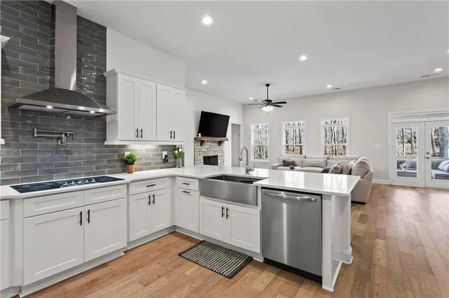 a kitchen with white cabinets sink and stove
