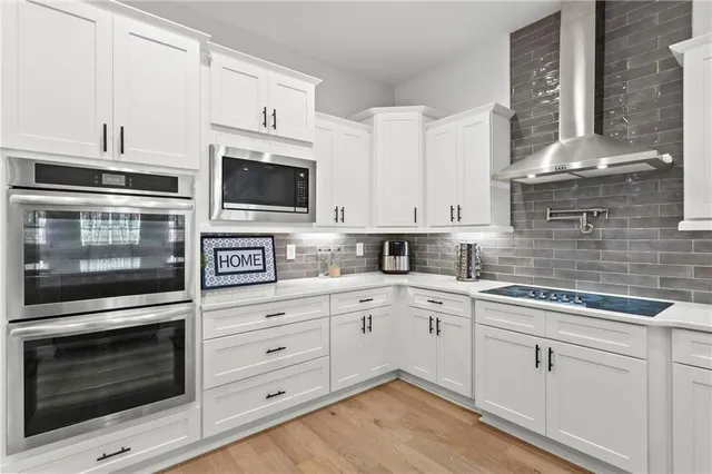 a kitchen with white cabinets stainless steel appliances and sink