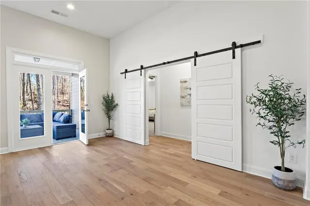 a view of an empty room with a window and wooden floor