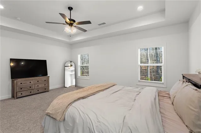 a bedroom with a bed a flat screen tv and a window