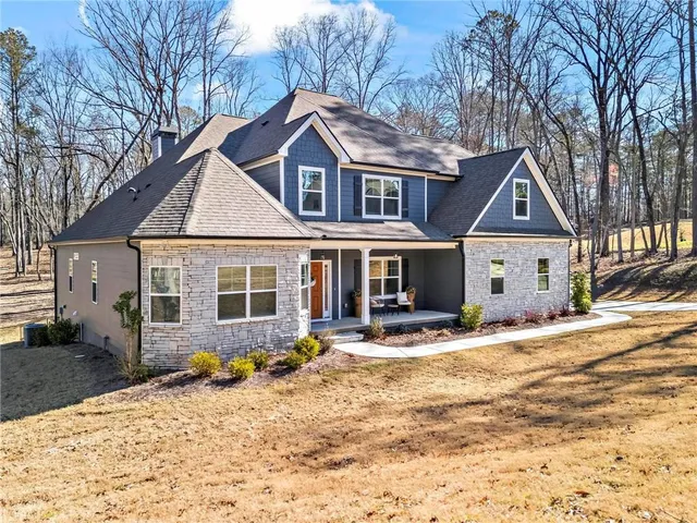 a front view of a house with a yard and trees