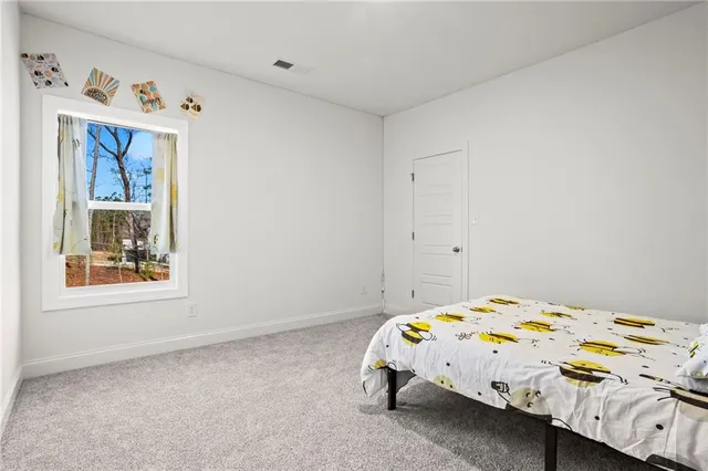 a bedroom with a bed and painting on the wall