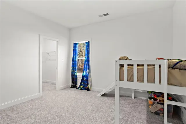 a view of an empty room with window and furniture