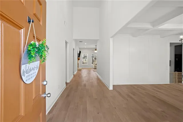 a view of a hallway with wooden floor and entryway