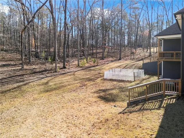 a view of backyard with wooden fence