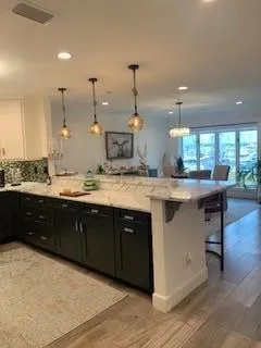 a kitchen with a sink a counter space appliances and cabinets
