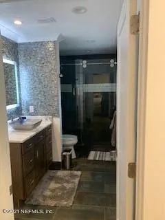 a bathroom with a sink a toilet and shower