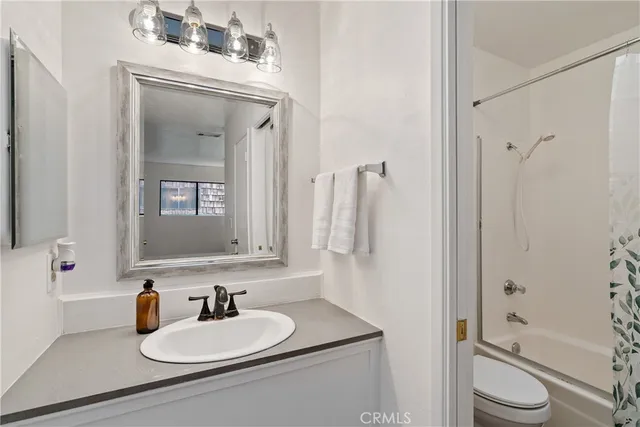a bathroom with a toilet a sink and a mirror