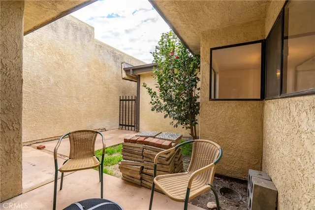 a backyard with table and chairs with potted plants