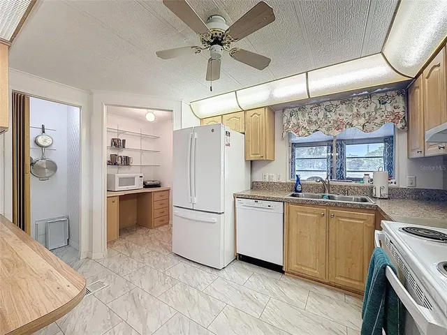 a large kitchen with kitchen island a stove a sink dishwasher and white cabinets with wooden floor