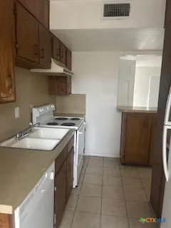 a kitchen with a sink a stove and cabinets