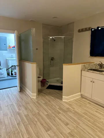 a view of a kitchen with wooden floor and electronic appliances