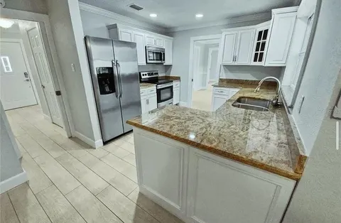 a kitchen with stainless steel appliances granite countertop a sink stove and refrigerator