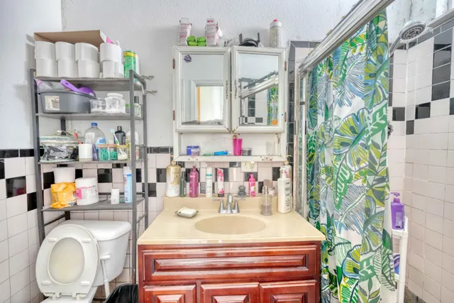a bathroom with a granite countertop sink mirror and a bathtub