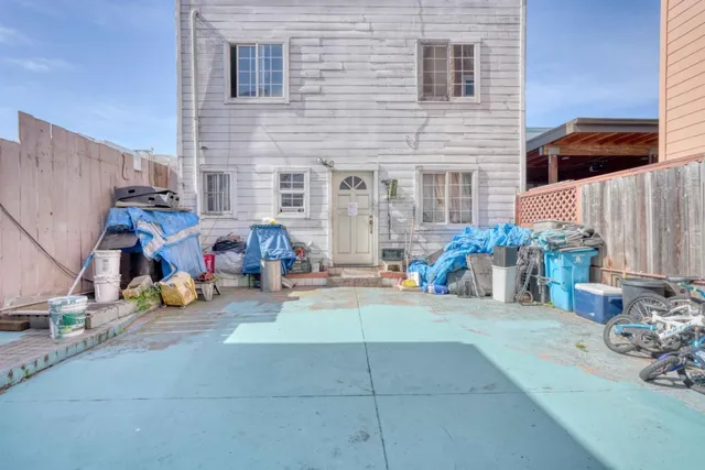 a view of a chair and table in the back yard of the house
