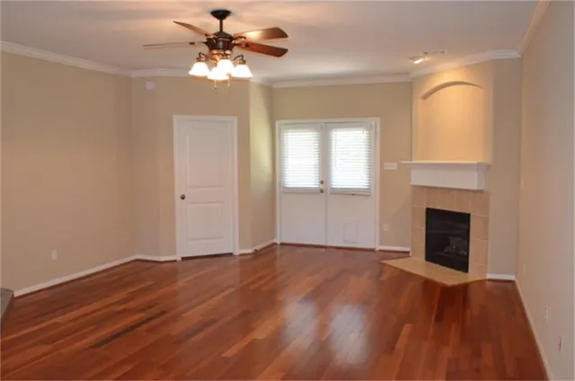 a view of an empty room with window and wooden floor