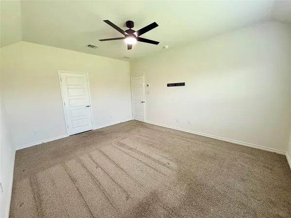 an empty room with a ceiling fan and a window