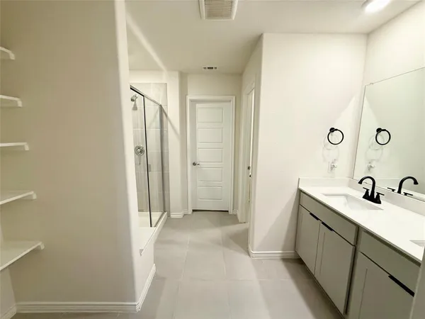 a bathroom with a double vanity sink a mirror and a shower