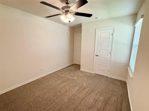 an empty room with chandelier fan