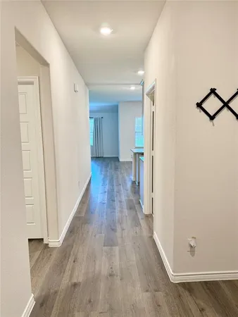 a view of a hallway with wooden floor