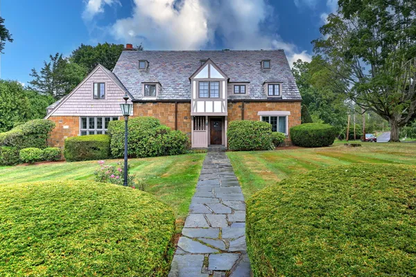 a front view of a house with yard and green space