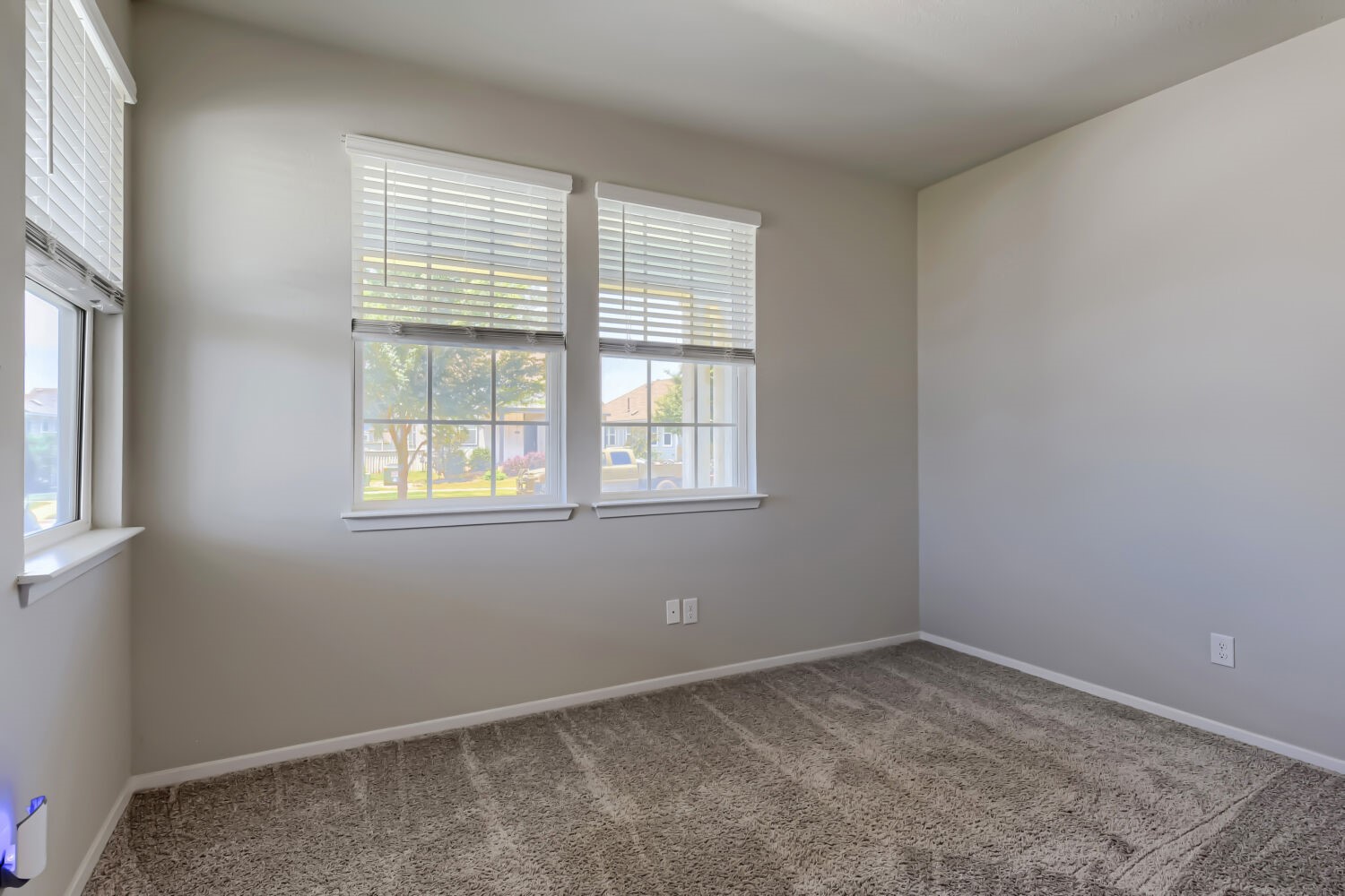 1310 Goforth Road Kyle, TX 78640 - Photo 18 of 24 Carpeted room featuring multiple windows with blinds, light gray walls, and white trim