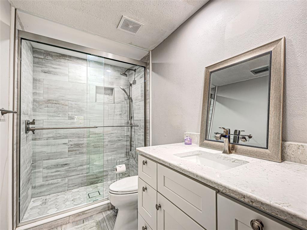 260 Santa Maria Street, Unit 109 Venice, FL 34285 - Photo 32 of 64 a bathroom with a granite countertop sink toilet and shower