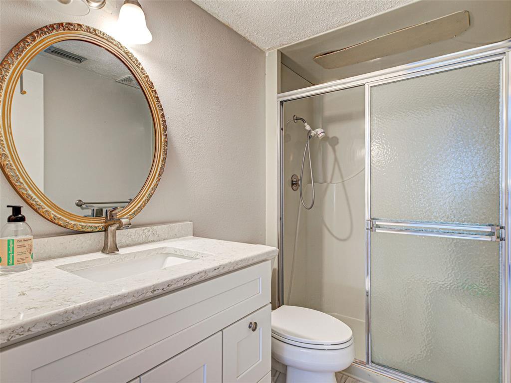 260 Santa Maria Street, Unit 109 Venice, FL 34285 - Photo 39 of 64 a bathroom with a granite countertop sink mirror vanity and toilet