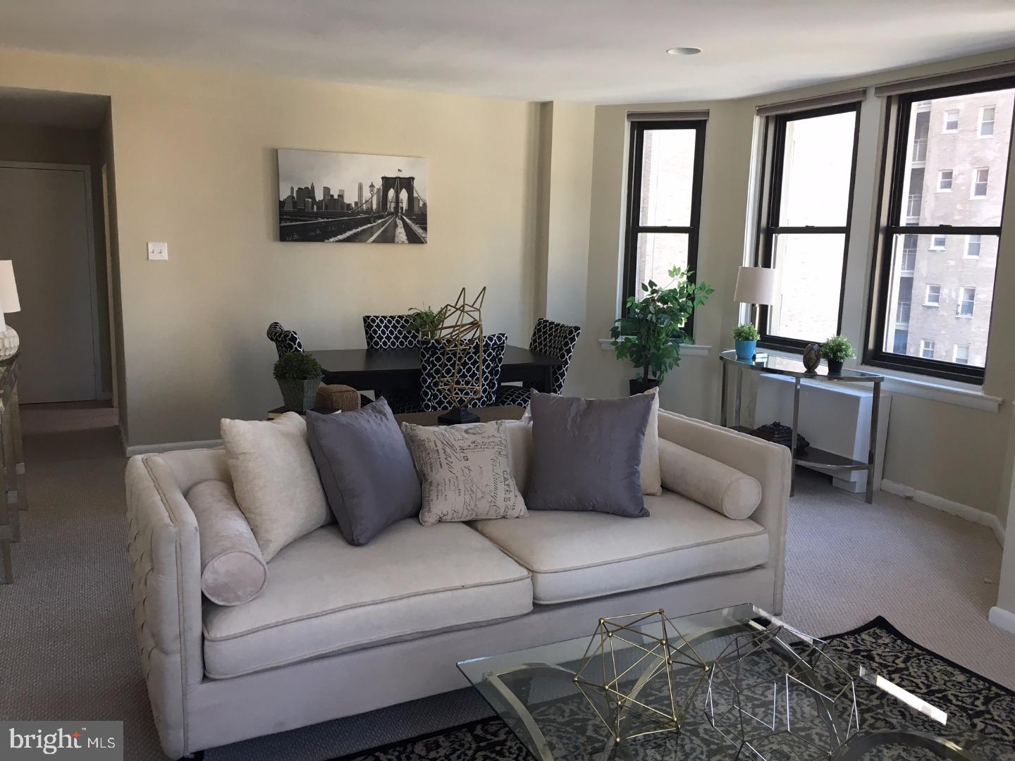 135 South 19th Street, Unit 804 Philadelphia, PA 19103 - Photo 5 of 18 a living room with furniture and floor to ceiling windows
