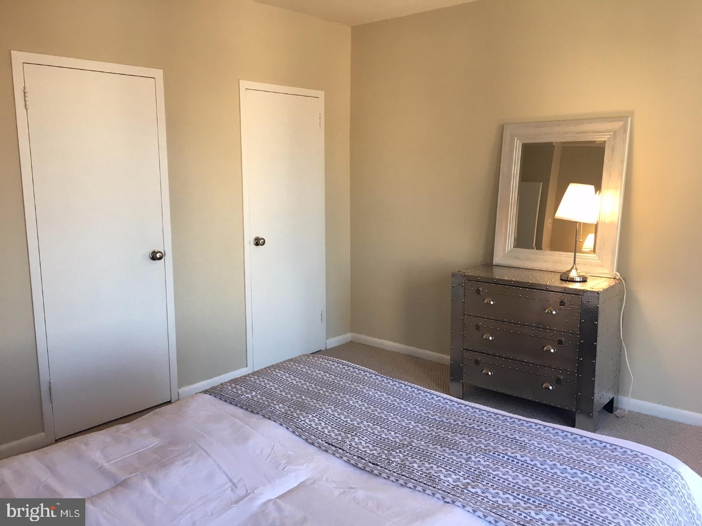 135 South 19th Street, Unit 804 Philadelphia, PA 19103 - Photo 10 of 18 a bedroom with a bed and a mirror