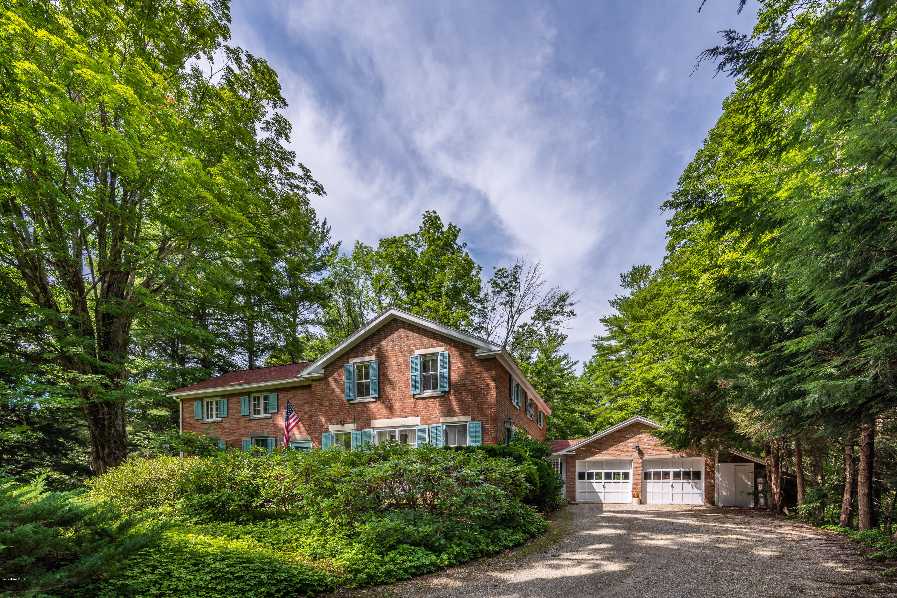 a front view of a house with a yard and trees
