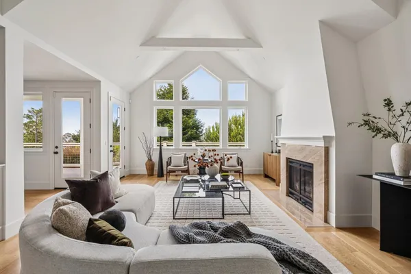 a living room with furniture a fireplace and a large window