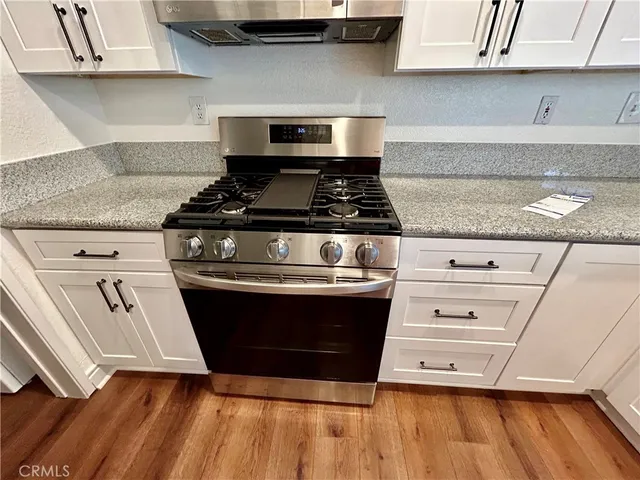 a stove top oven sitting inside of a kitchen