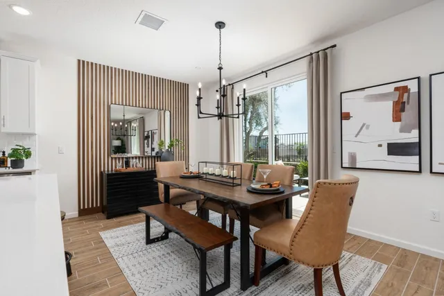 a dining room with furniture a chandelier and wooden floor