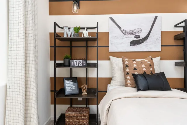 a bedroom with a bed and painting on the wall