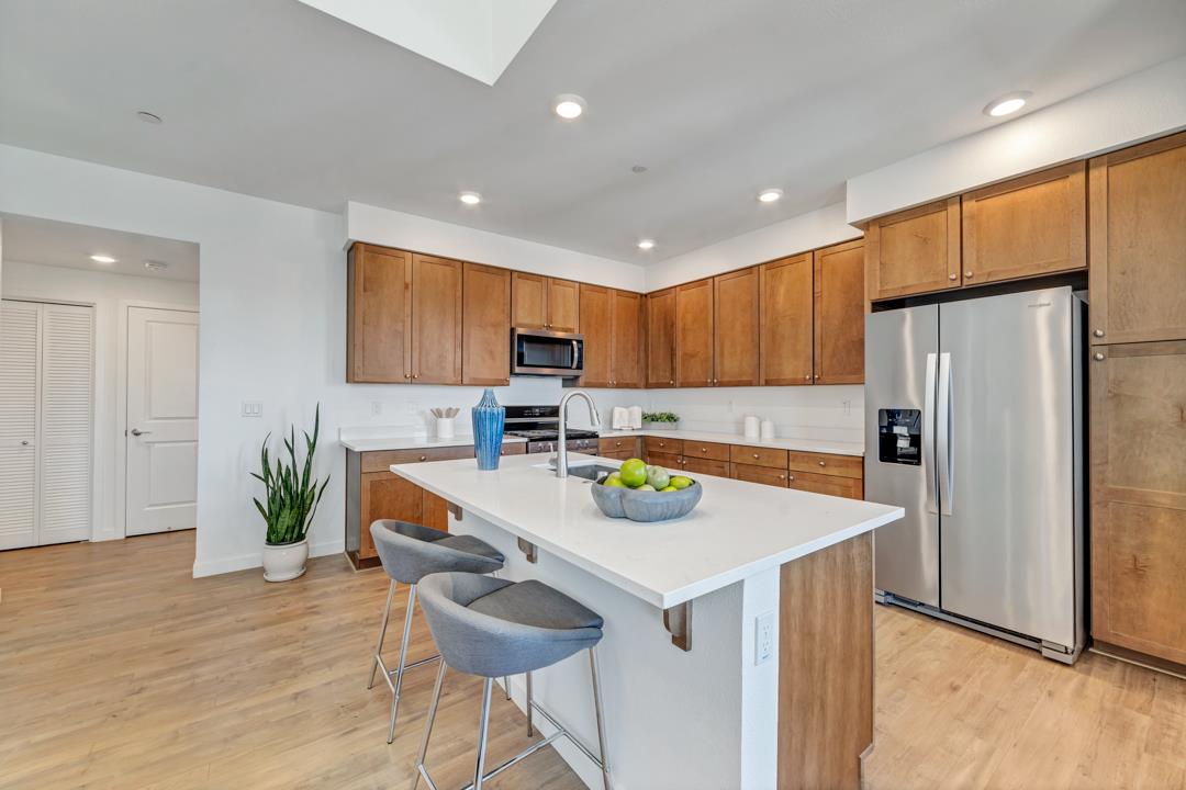 1421 Nightshade Road, Unit 40 Milpitas, CA 95035 - Photo 4 of 29 a kitchen with stainless steel appliances a table chairs refrigerator and microwave