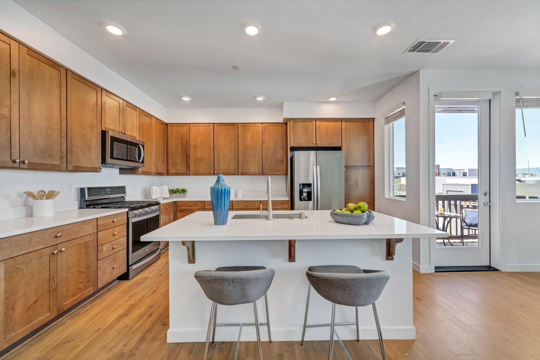 1421 Nightshade Road, Unit 40 Milpitas, CA 95035 - Photo 6 of 29 a kitchen with stainless steel appliances granite countertop a stove top oven a sink a dining table and chairs