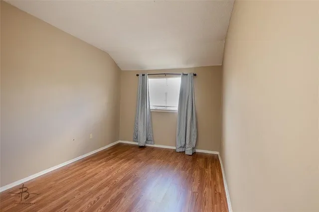 a view of a room with wooden floor and white walls